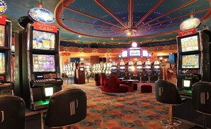 Ein Casino mit mehreren Spielautomaten, einer Drehscheibe und einem auffälligen Deckenstil.