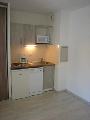 A compact kitchen with a microwave, coffee maker, and dishwasher. - Appartement 3 étoiles - ccbgfdc (Allevard)