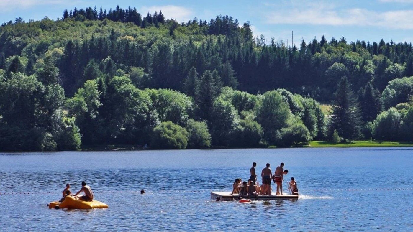 Un lago con gente en un bote y una balsa amarilla.