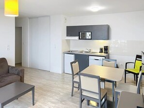 A compact living space with a kitchenette, a dining area, and a sofa. - Appartement 3 étoiles - ccbgffi (Rouen)