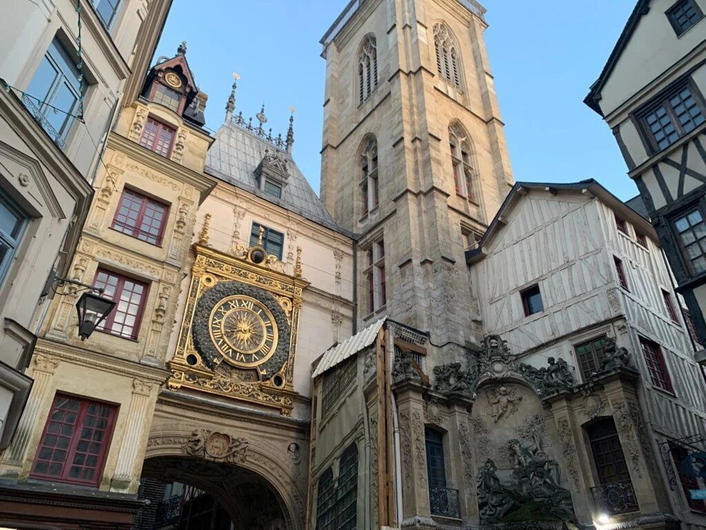 Un edificio histórico con arquitectura ornamentada, una imponente torre de reloj y una fachada detallada.