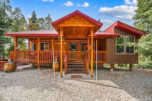 A log cabin with a porch, a deck, and a separate cabin section. - The Office With Hot Tub and Dogs OK (Duck Creek Village)
