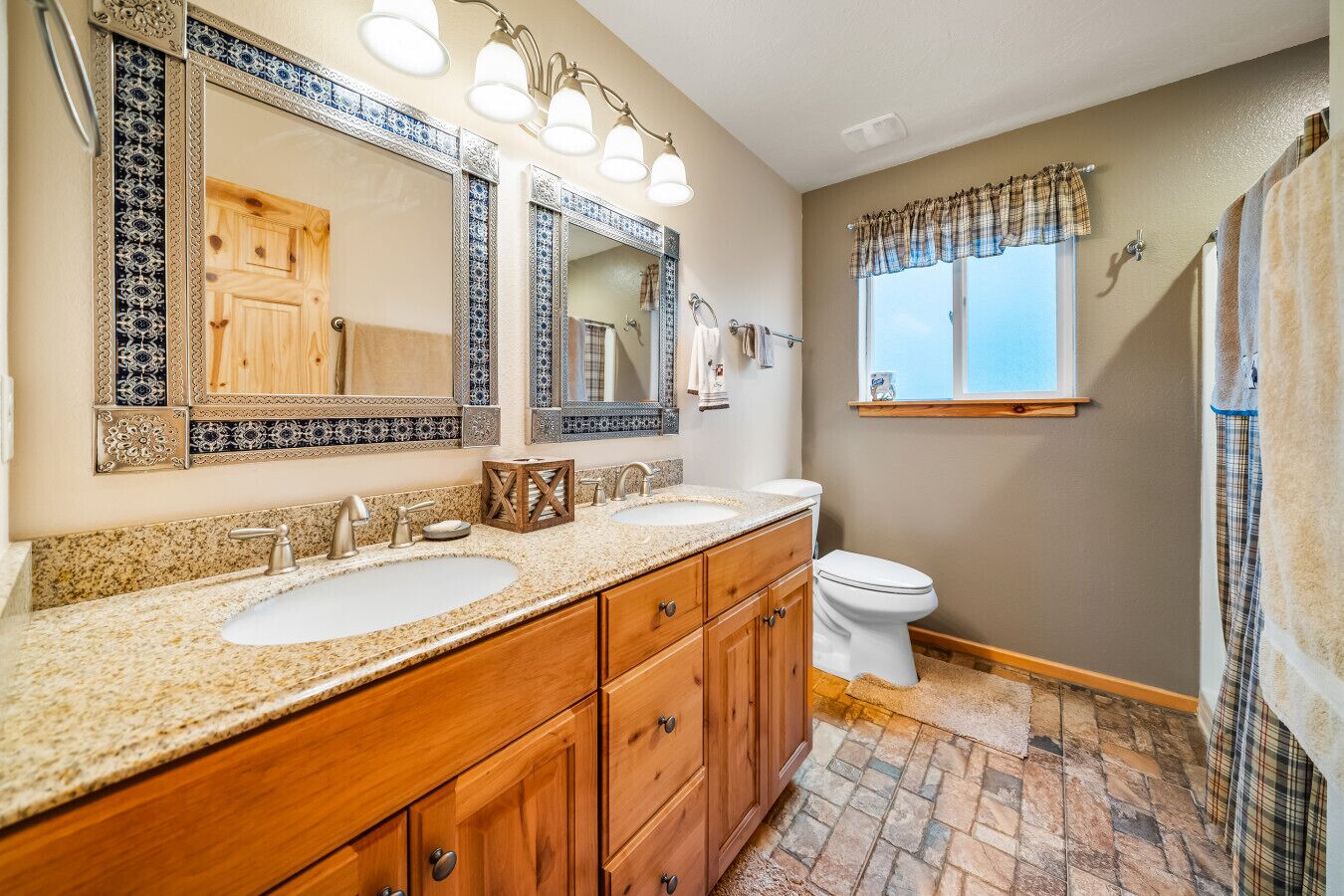 Une salle de bain avec deux lavabos, des toilettes et une douche.