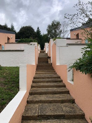 A staircase leading to a row of buildings with a uniform exterior. - Camping 2 étoiles - Piscine  - ccbgfeb (Pluherlin)