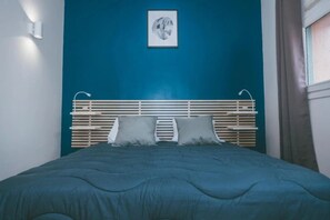 A bedroom with a bed, a headboard, a wall-mounted light, and a framed picture. - Camping 2 étoiles - Piscine  - ccbgfed (Pluherlin)