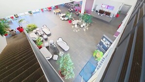 Eine geräumige Lobby mit Sitzbereichen, einer Rezeption und Topfpflanzen.