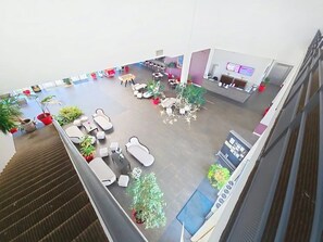 A spacious lobby with seating areas, a reception desk, and potted plants. - Appartement 3 étoiles - Piscine  - ccbgfdh (Amboise)