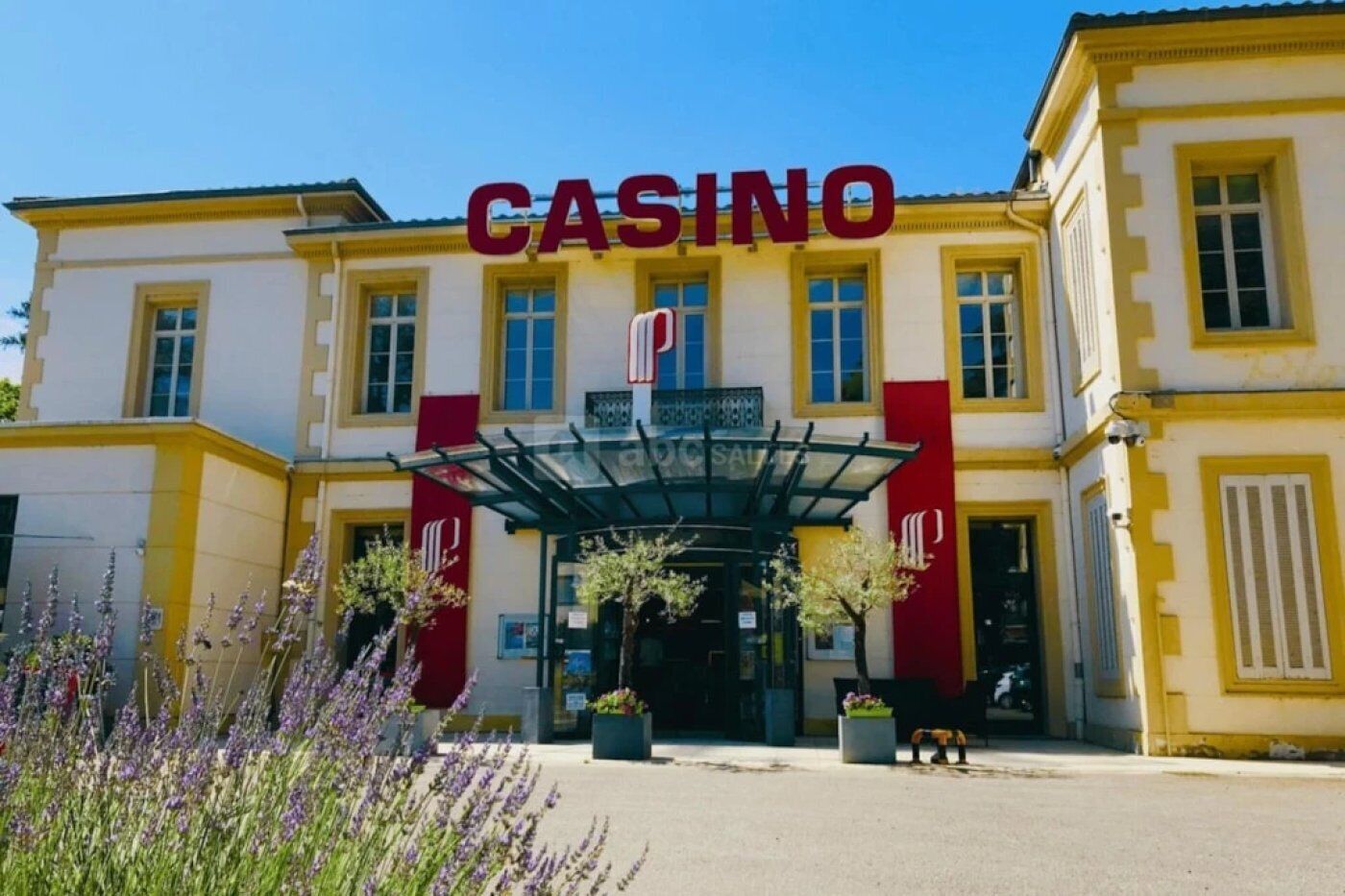 A building with a prominent 'CASINO' sign, a covered entrance, and a symmetrical facade with yellow and red accents.