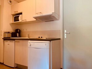 A compact kitchen with a microwave, coffee maker, and dishwasher. - Appartement 3 étoiles - Piscine  - ccbgfcd (Gréoux-les-Bains)