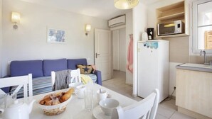A compact living space with a kitchenette, a dining area, and a seating area with a sofa and chairs. - Appartement 3 étoiles - ccbgfbg (Cabriès)