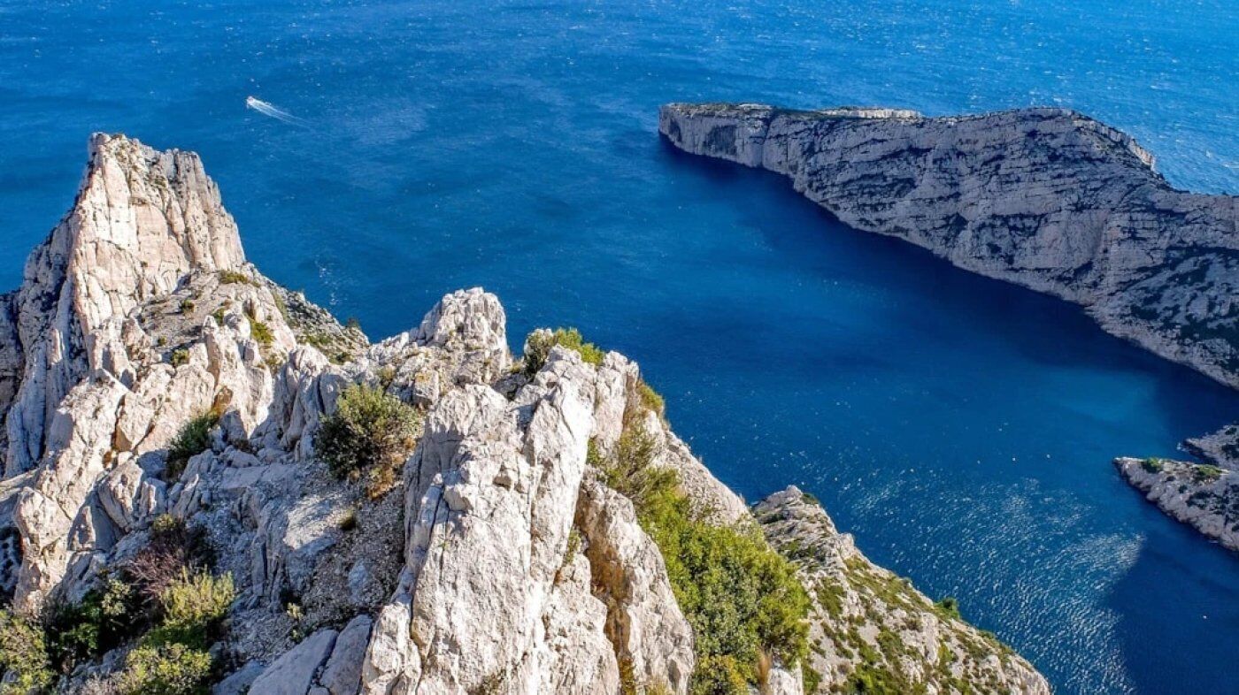 Une côte accidentée, avec de hautes falaises rocheuses et une mer d’un bleu limpide.