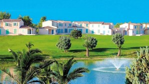 A row of villas with a grassy lawn and a small pond with a fountain. - Appartement 3 étoiles - ccbgfbg (Cabriès)