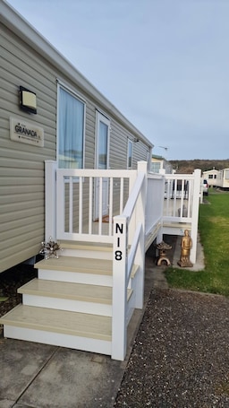 A mobile home with a white porch and steps marked 'N18'.. Beachside Retreat Chapel St Leonards