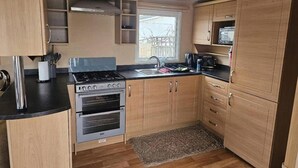 Ett kompakt kök med en gasspis, ugn och en mikrovågsugn.