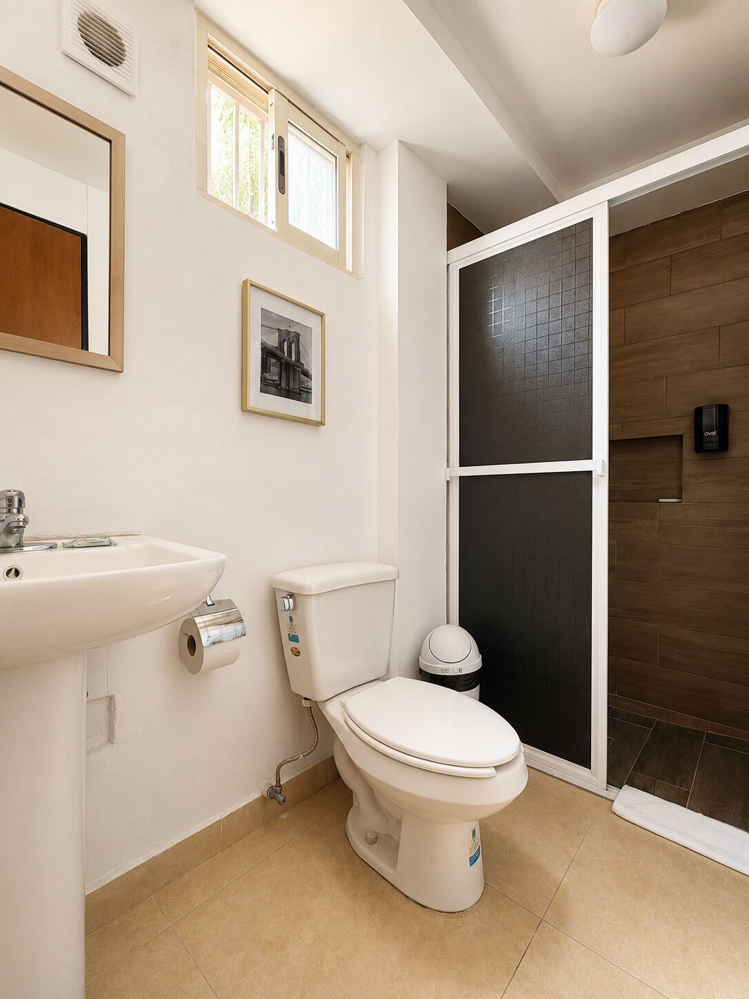 A bathroom with a toilet, sink, and a shower area.