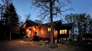 Une cabane en bois avec une véranda, des marches et une porte bien visible.