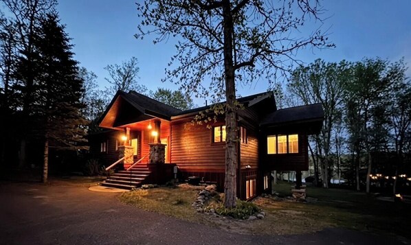 Une cabane en bois avec une véranda, des marches et une porte bien visible.