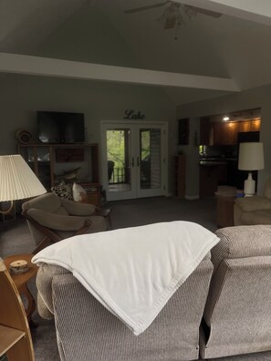Ein Wohnzimmer mit Fernseher, Kamin, Essbereich und Küche.