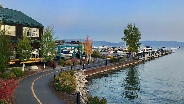 A waterfront walkway with a building on the left, a dock with boats, and a clear view of the water. - 3BR / 3BA McKinney Creek Cabin!  EV Charger! (Tahoma)