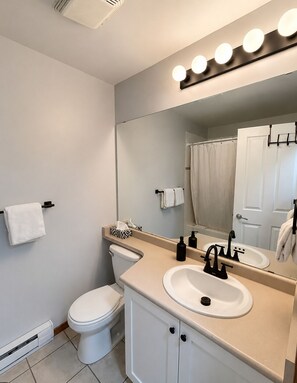 Une salle de bain moderne équipée de toilettes, d’un lavabo et d’un miroir.