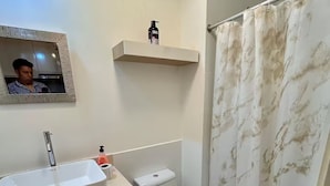 Ein Badezimmer mit Waschbecken, Toilette und Duschvorhang.