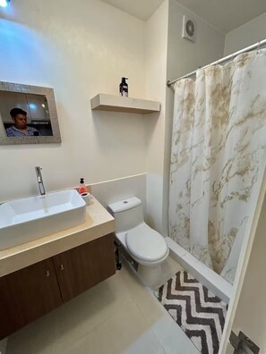 Ein Badezimmer mit Waschbecken, Toilette und Duschvorhang.