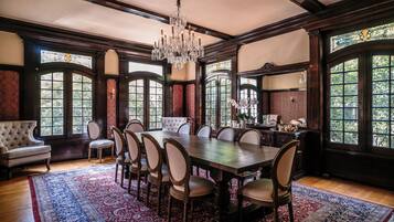 A formal dining room with a large wooden table, upholstered chairs, and a chandelier.