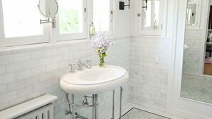 A bathroom with a white sink, two mirrors, a radiator, and a trash can. - The George & Martha Room @ Portland's White House Bed & Breakfast (Portland)