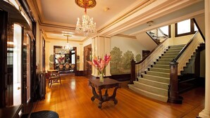 A grand foyer with a chandelier, a staircase, and a dining area. - The George & Martha Room @ Portland's White House Bed & Breakfast (Portland)