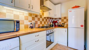Eine Küche mit Mikrowelle, Herd, Backofen und Kühlschrank.