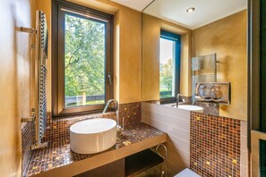 A bathroom with a large window, a sink, and a mirror.