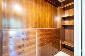 A wooden wardrobe with multiple drawers and shelves.