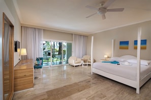A hotel room with a bed, a desk, a chair, and a view of the outdoors. - Beautiful 1-bdrm suite steps from the beach in Puerto Plata with deck and AC (Puerto Plata)