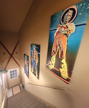 A staircase with three framed artworks on the wall.