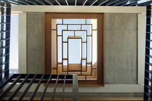 A room with a window, a metal railing, and a concrete wall. - Southwark Brick House - Bermondsey London (London)