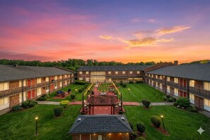 A hotel with a central courtyard, multiple guest rooms, and a well-maintained lawn. - Quaint Charlotte StudioAPT withA/C 24hrGym 7Mins toHospitals&DowntownFreeParking (Charlotte)
