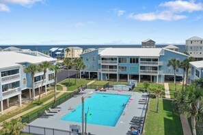 Ein Resort mit einem großen Schwimmbad, mehreren Gebäuden und Blick auf den Ozean.