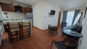 A compact living space with a kitchen, dining area, and a small seating area. - Bungalows Huerta del Mar (Santa Cruz)