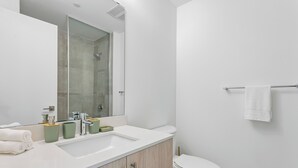 A modern bathroom with a white sink, mirror, and toilet. - Home Richmond Hill 2bed2bath | Parking (Richmond Hill)