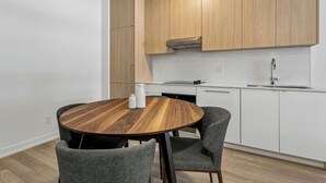 A modern kitchen with wooden cabinets, a round dining table, and grey chairs. - Home Richmond Hill 2bed2bath | Parking (Richmond Hill)