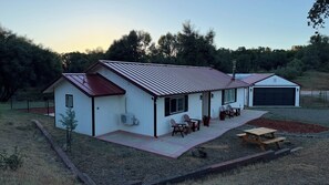 Ein eingeschossiges Haus mit überdachter Terrasse, Garage und kleinem Garten.