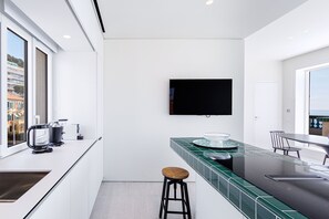 Eine moderne Küche mit großem Fenster, Flachbildfernseher und einer Bar.
