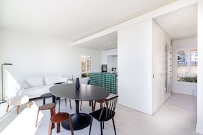 Ein modernes Interieur mit Essbereich, Sofa und Küche.