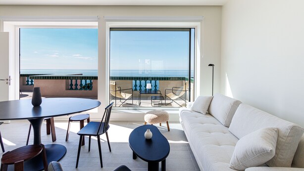 A balcony with a view of the sea, a round table with chairs, a sofa, and a lamp. - Magnificent apartment (Nice)