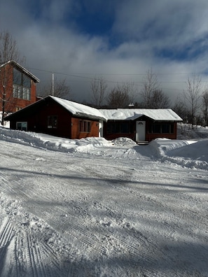A snow-covered landscape with two wooden cabins and a modern building in the background. - Killington / Rutland   2 Bdrm Cabin w/ Mtn view (Mendon)