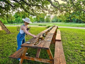 Ett picknickbord står utomhus och en person håller på att duka fram.
