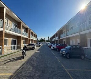 A multi-story parking garage with cars parked on both sides. - Sonia Flats - No Laguna Residence Portinho - Opposite the Itajuru Canal (Cabo Frio)