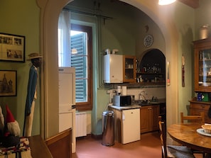 A kitchen with a refrigerator, microwave, sink, and wooden cabinets. - Florentine Renaissance, to experience authentic Florence in the heart of the city (Firenze)