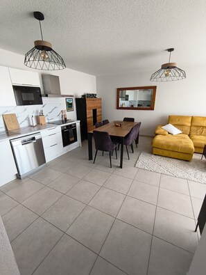 Eine moderne Küche mit Essbereich, einer Couch und einem Spiegel.