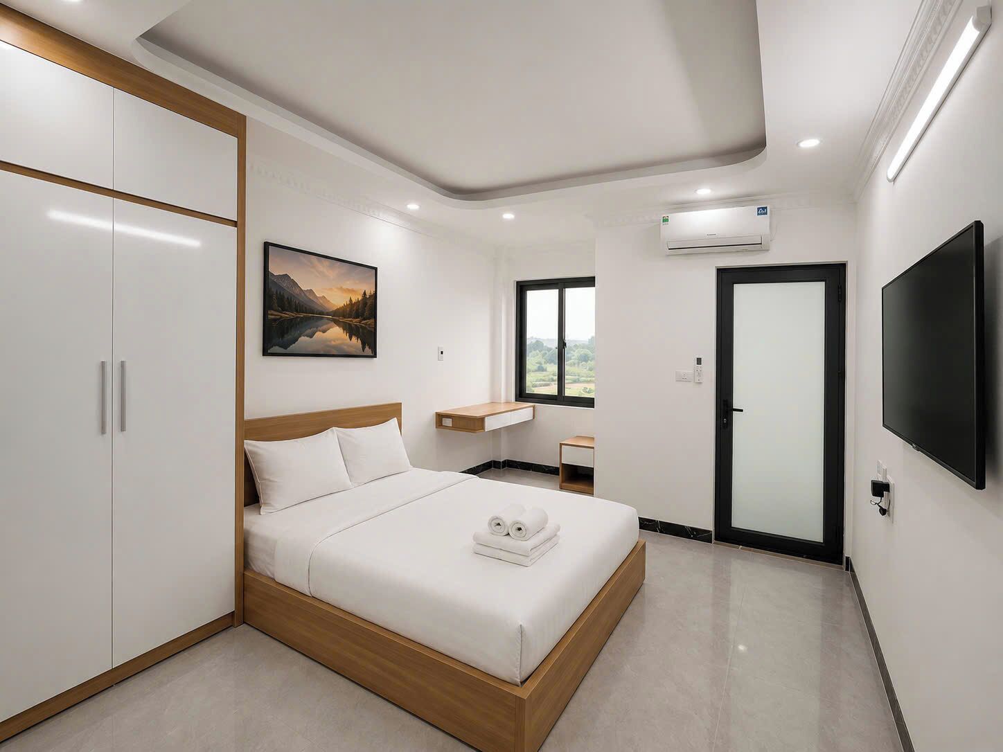 A modern hotel room with a bed, wardrobe, TV, and a painting.